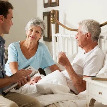 Elderly couple chat to a doctor